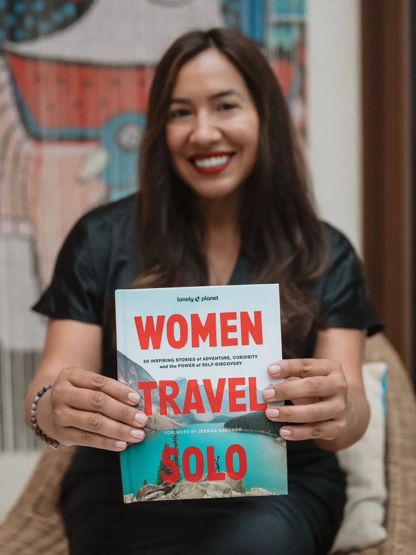Jeannette Ceja holding the Lonely Planet book Women Travel Solo